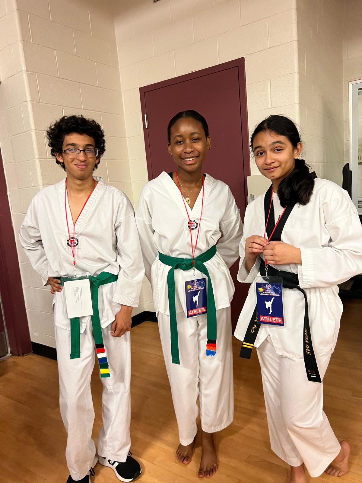 Siona supporting younger martial-arts athletes in a mentorship setting.