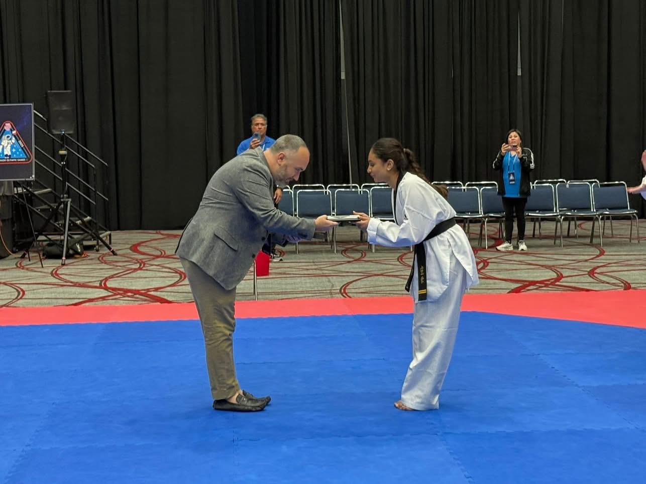Siona demonstrates a Taekwondo technique in competition.