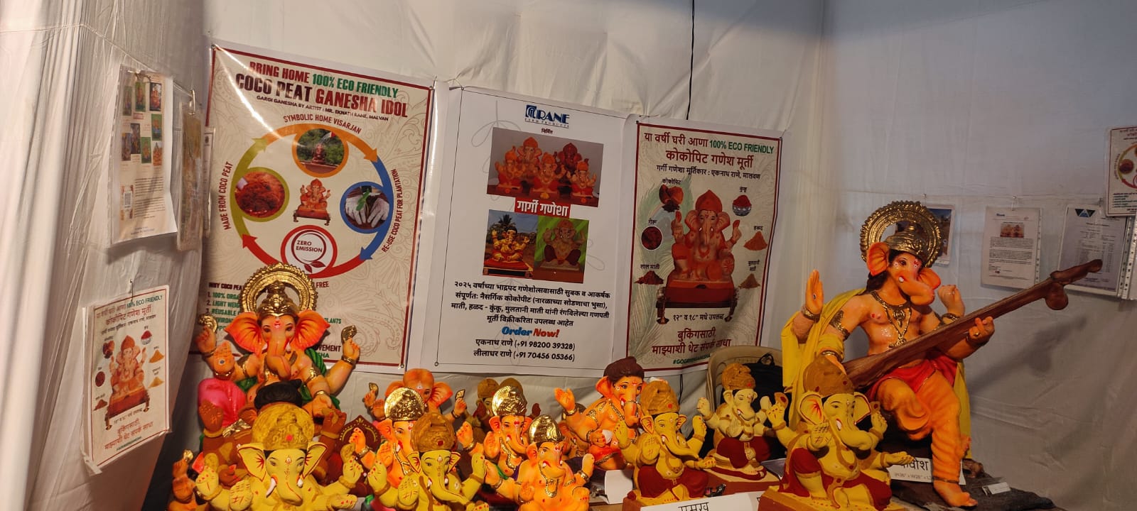 Collection of colorful coco peat Ganesha idols with eco-friendly posters in the background